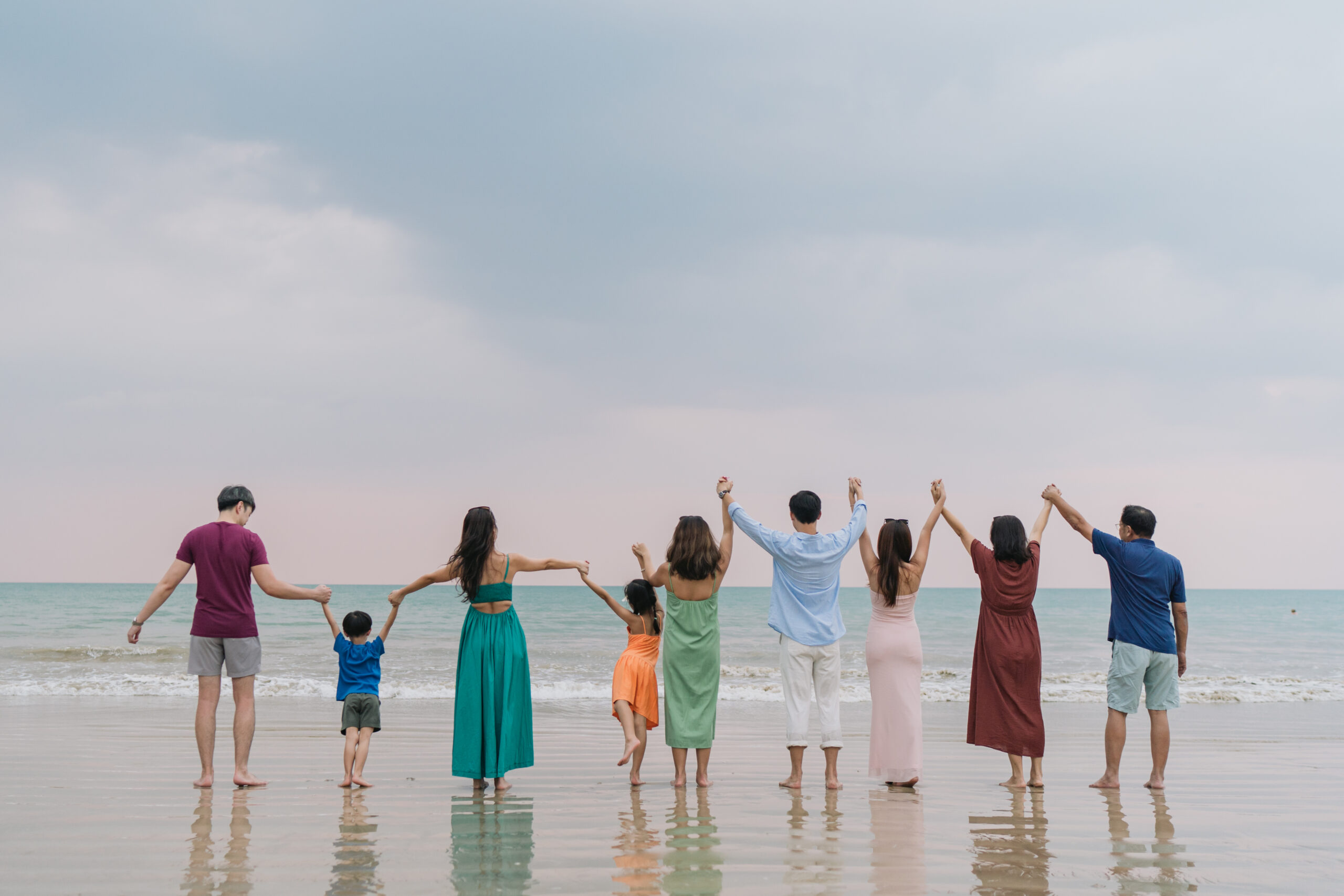 Family cuddling under palm trees at JW Marriott Khao Lak
